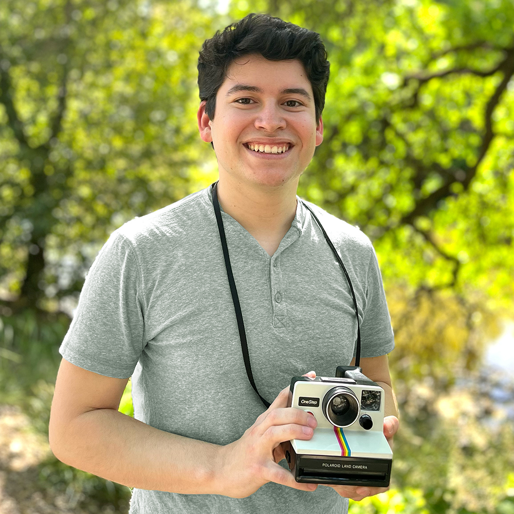 Mechanical engineering graduate student Marc Corfmat holds a vintage Polaroid OneStep camera.