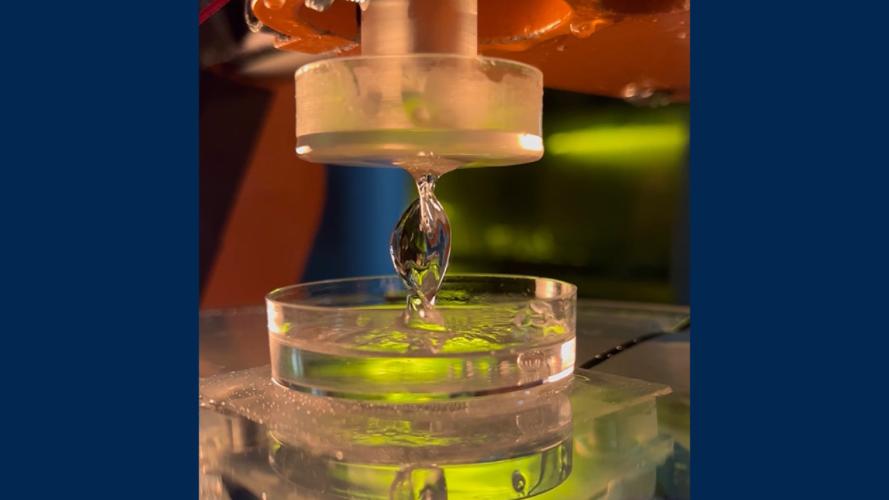 A robot arm pulls out a helix shape from resin