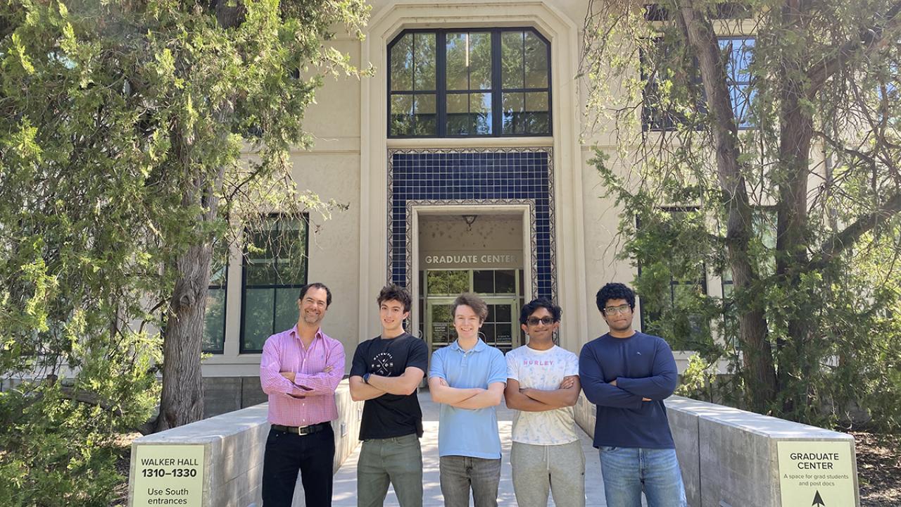Five people stand outside of an engineering building on the UC Davis campus