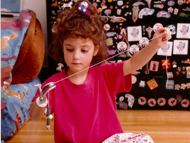 Young Tal Oppenheimer stringing beads