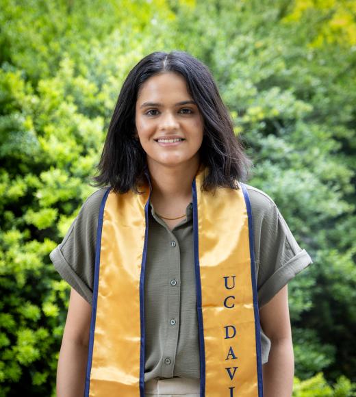 Lovleen Kaur stands in front of a green and yellow background