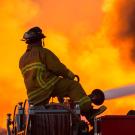 Firefighter shoots water at an active fire