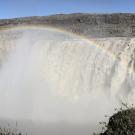 A rainbow arching over a waterfall