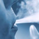 A person blowing smoke out of their mouth